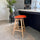 Soho Clear and Orange Plastic Bar Stool with Light Wood Legs